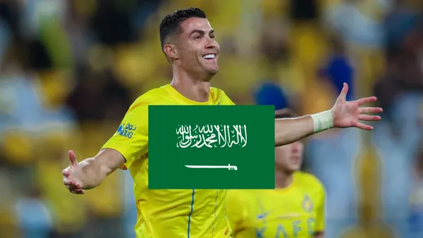 Cristiano Ronaldo opens his arms with a smile on his face while wearing the Al Nassr shirt.