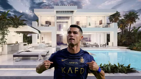 Cristiano Ronaldo points at himself while wearing the Al Nassr jersey and a mansion is behind him.