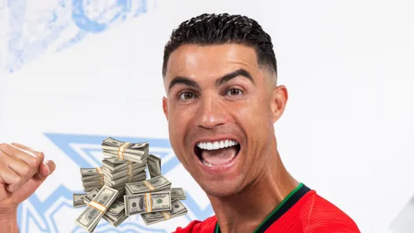 Cristiano Ronaldo screams with joy as he wears the new Portugal EURO national team jersey and a stack of cash is next to him.