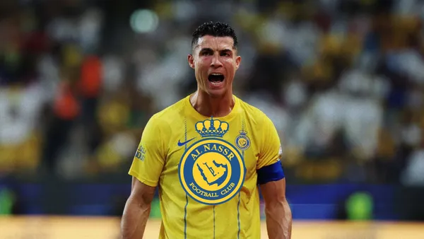 Cristiano Ronaldo screams with passion while wearing the Al Nassr jersey and the Al Nassr badge is in the middle.