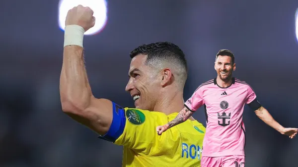 Cristiano Ronaldo smiles with his fist up in the air while Lionel Messi smiles with his arms out wearing an Inter Miami jersey.