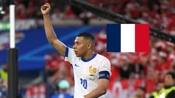 Kylian Mbappé celebrates a France goal while wearing the France jersey and the French flag is next to him. (Source: Statman Dave X)