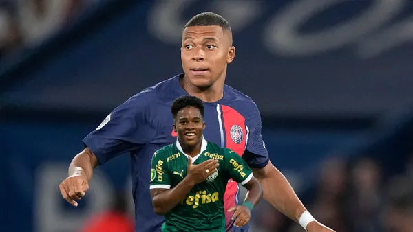 Kylian Mbappé looks to his right while wearing a PSG jersey and Endrick pats on the Palmeiras badge.