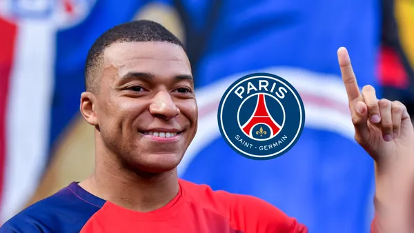 Kylian Mbappé smiles before his last PSG match at the Parc des Princes and the PSG logo on the side.