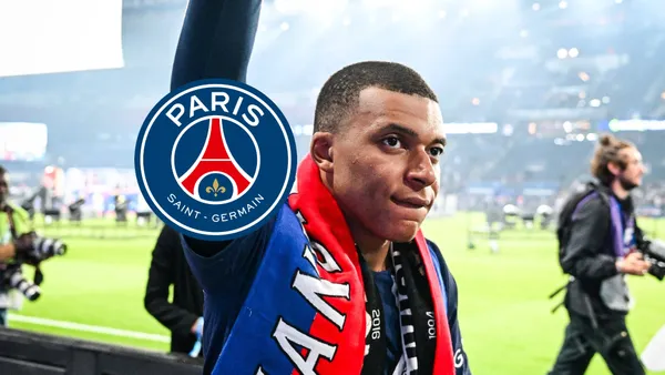 Kylian Mbappé wears a PSG scarf on while he looks at the crowd and the PSG badge is next to him.