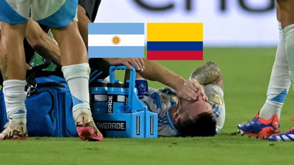 Lionel Messi cries on the pitch on the ground in pain in the Copa America final with the Argentina and Colombia flags above him. (Source: Messi Xtra X)