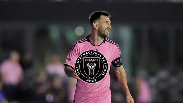 Lionel Messi looks to the left while wearing the Inter Miami kit as the Inter Miami badge is in the middle.