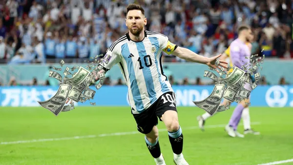 Lionel Messi opens his arms out with the Argentina national team jersey and flying bills are next to him.