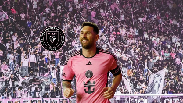 Lionel Messi smiles as he wears the Inter Miami jersey while the club badge is next to him and the Inter Miami fans are in the background. (Source: Inter Miami X)