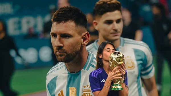 Lionel Messi wears the Argentina jersey and Antonella Roccuzzo kisses the World Cup trophy. (Source: Messi Xtra X)