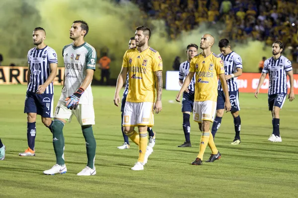 Monterrey and Tigres players talk onto the pitch.