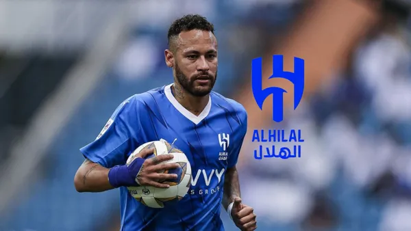 Neymar Jr. holds a ball while wearing the Al Hilal jersey and the Al Hilal logo is next to him.