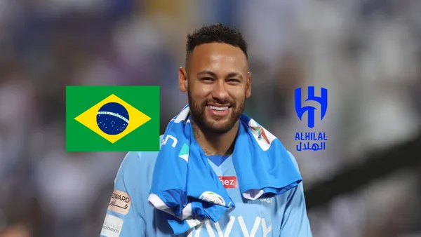 Neymar smiles as he wears the Al Hilal jersey while the Brazil flag and the Al Hilal badge is next to him on the sides. (Source: Getty Images)
