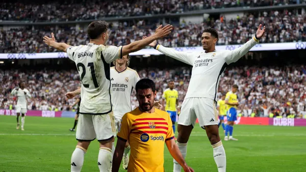 Real Madrid players celebrate their goal while FC Barcelona's Gundogan is upset.