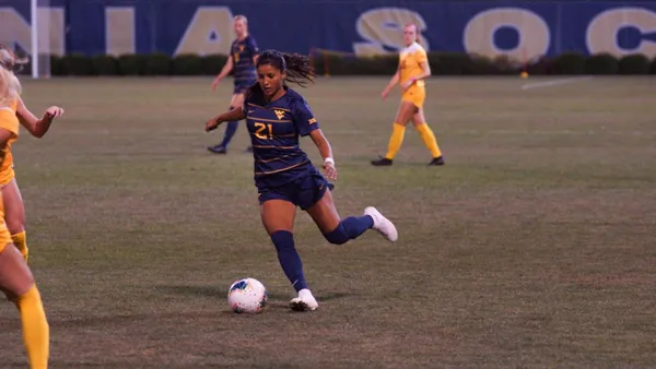 Stefany Ferrer Van Ginkel is playing football and is about to kick the ball.