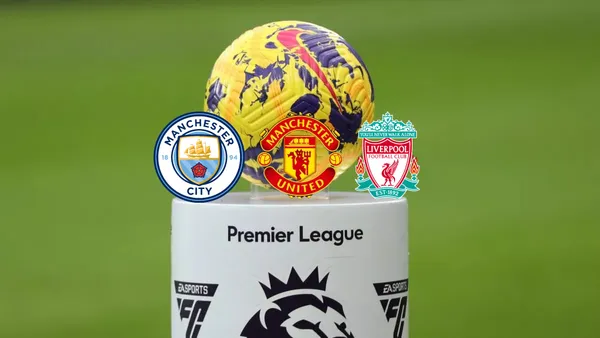 The Premier League ball is on a stand while the Manchester City, Manchester United, and the Liverpool badges are below it.