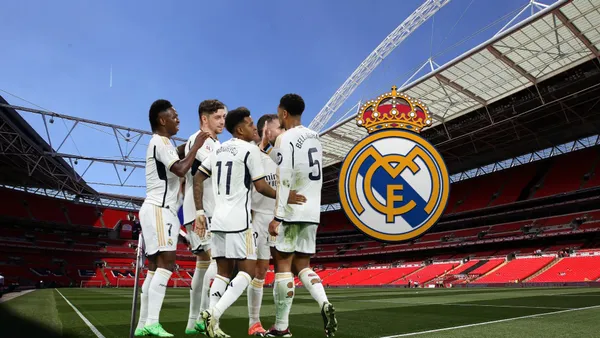 The Real Madrid team celebrate together while the Real Madrid badge is next to them; the background is Wembley Stadium.