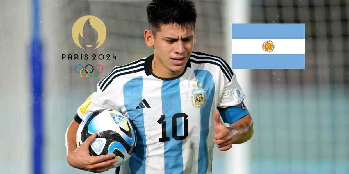 Claudio Echeverri holds the ball while playing for a youth Argentina national team as the Argentina flag and the Paris Olympics logo is next to him. (Source: Getty Images,