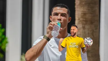 Cristiano Ronaldo drinks water while Neymar celebrates with a ball on his hand. 