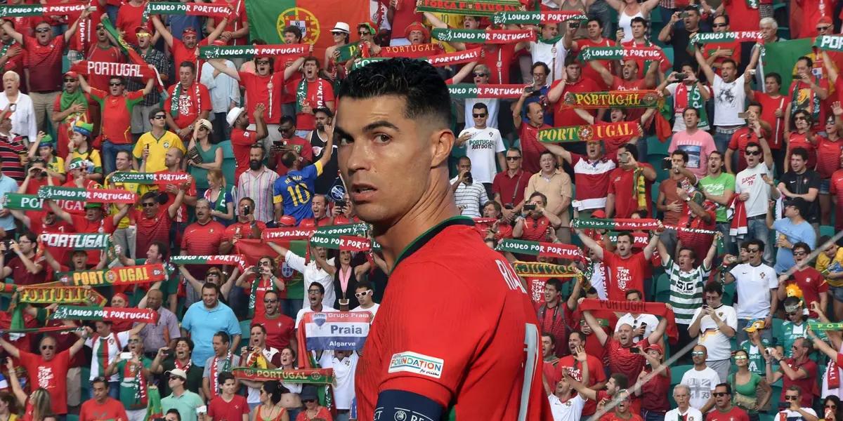 Cristiano Ronaldo looks back with a Portugal jersey on and in the background is Portuguese fans. (Source: Getty Images)