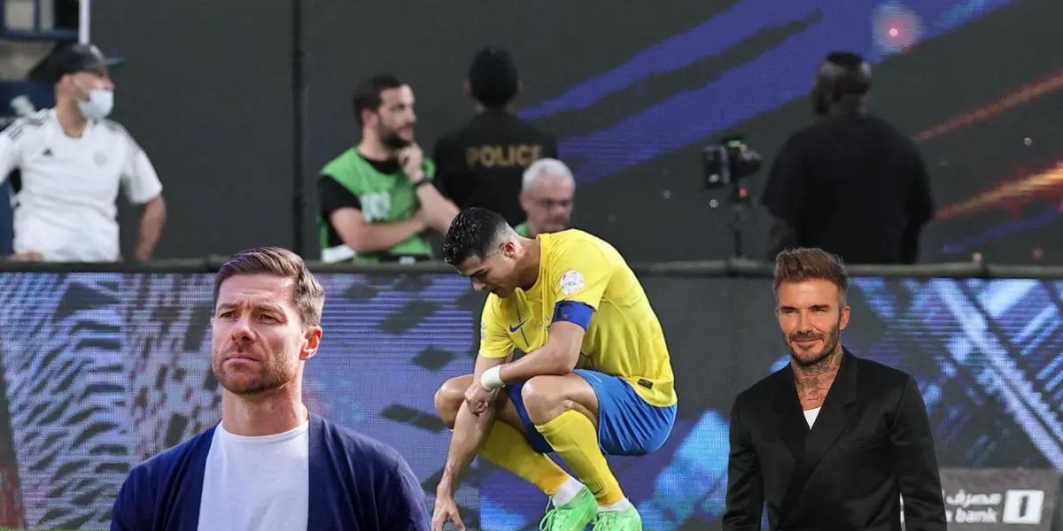 Cristiano Ronaldo looks down on the ground wearing an Al Nassr kit while Xabi Alonso and David Beckham is next to him.