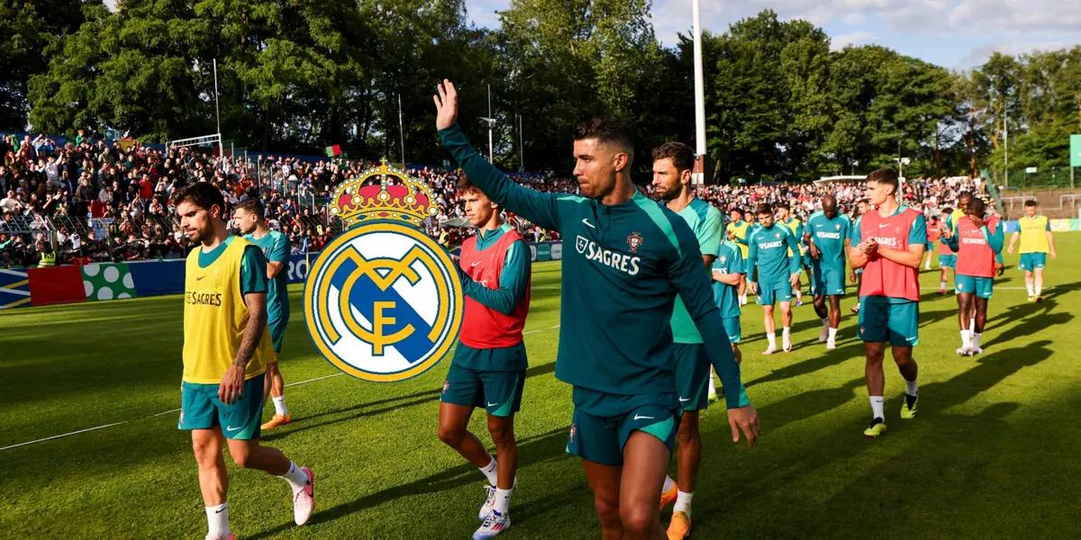 Cristiano Ronaldo waves to the fans while wearing the Portugal training kit and the Real Madrid badge is next to him.