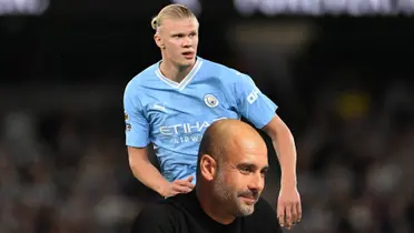 Erling Haaland concentrated wearing a Manchester City shirt while Pep Guardiola smiles.