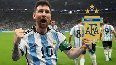 Lionel Messi celebrates a goal while wearing the Argentina national team jersey and the Argentina national team badge is next to him.