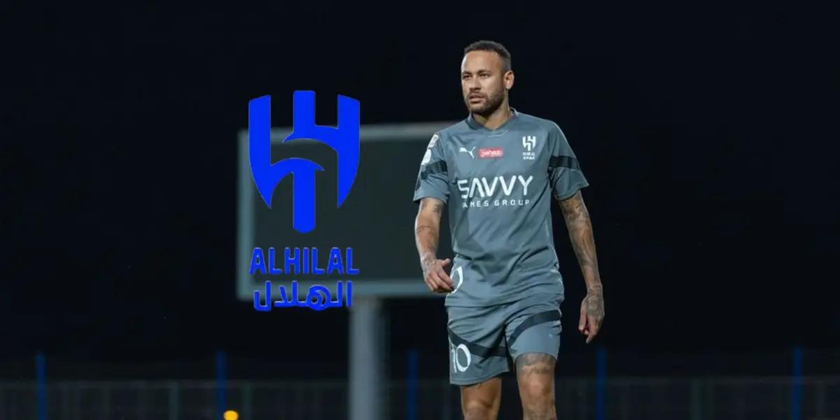 Neymar Jr is walking on the pitch wearing an Al Hilal training kit on while the Al Hilal logo is next to him.