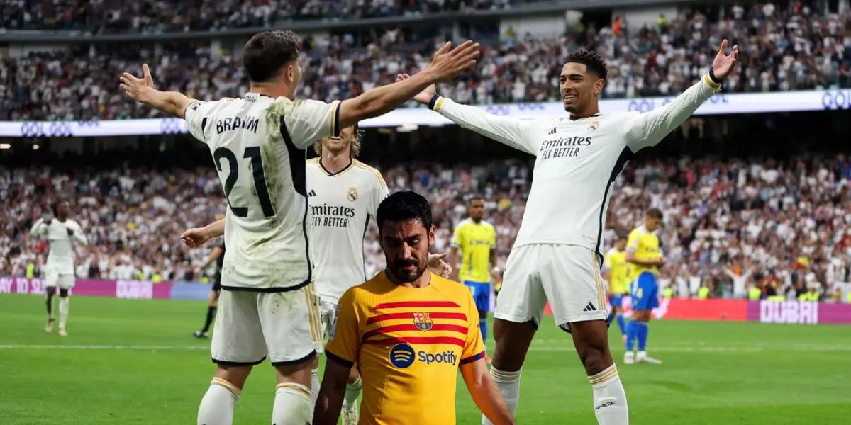 Real Madrid players celebrate their goal while FC Barcelona's Gundogan is upset.