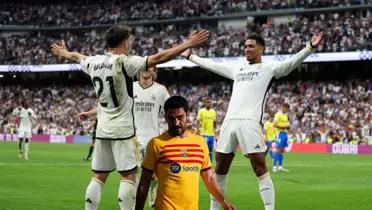 Real Madrid players celebrate their goal while FC Barcelona's Gundogan is upset.