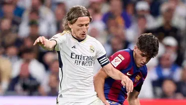 Real Madrid's Luka Modric disputing the ball against FC Barcelona's Pau Cubarsi.