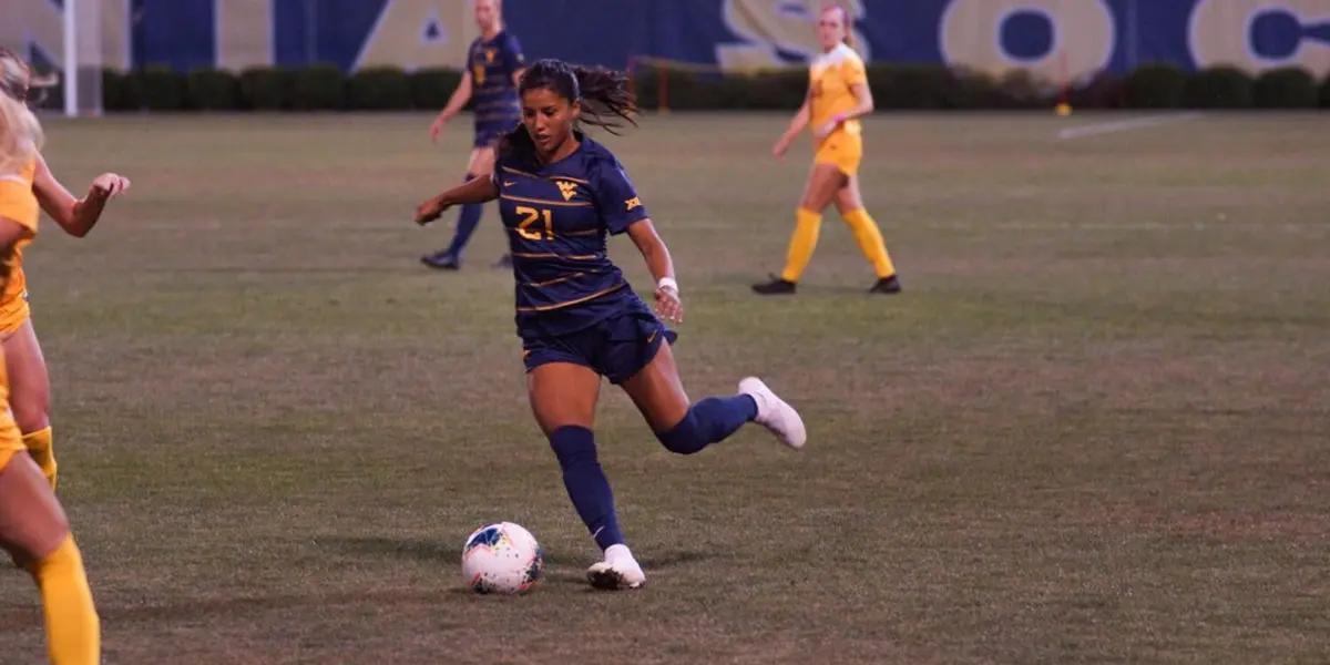 Stefany Ferrer Van Ginkel is playing football and is about to kick the ball.