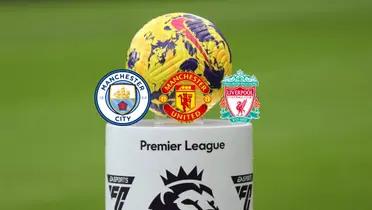 The Premier League ball is on a stand while the Manchester City, Manchester United, and the Liverpool badges are below it.